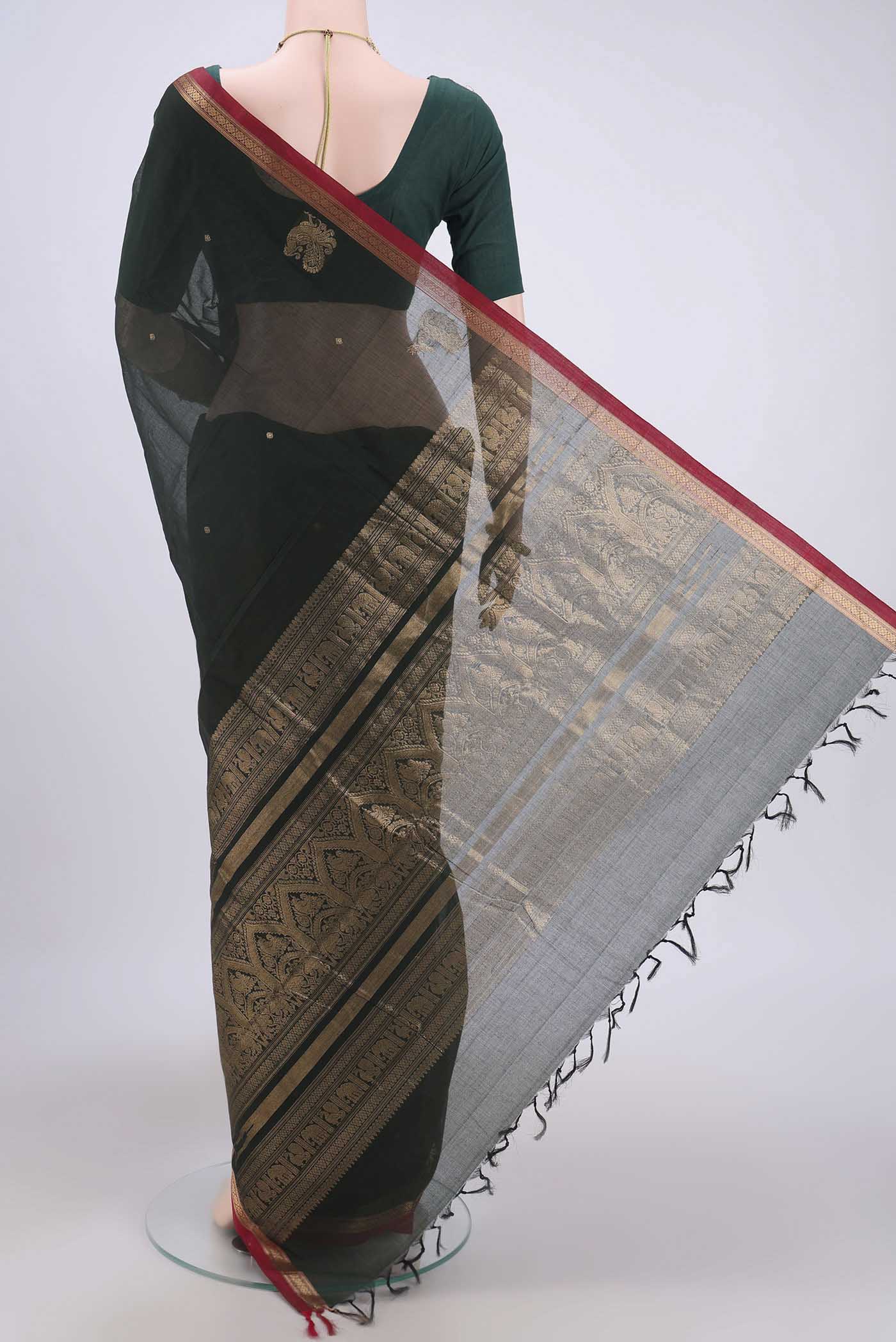 Flat view of Bottle Green Kanchi Cotton Saree with Zari Butta on the body and Zari Border. 