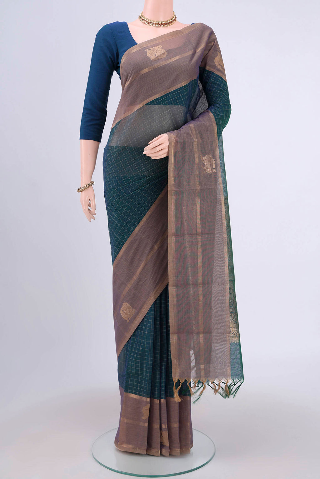 Bottle Green Kanchi Cotton Saree with Checked design on the body and Zari Border.  displayed on a mannequin