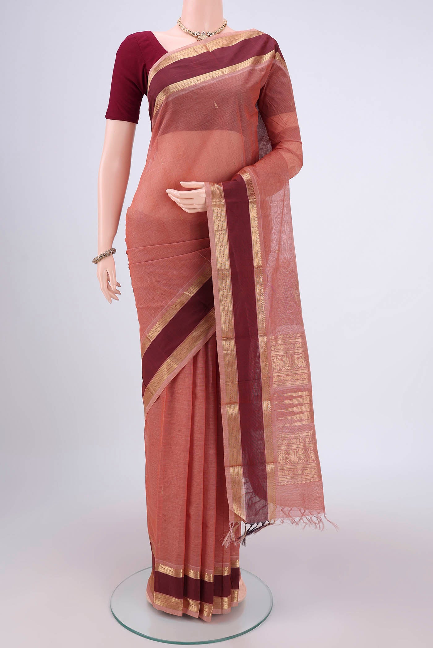 Coral Kanchi Cotton Saree with Plain Body and Zari Border.  displayed on a mannequin