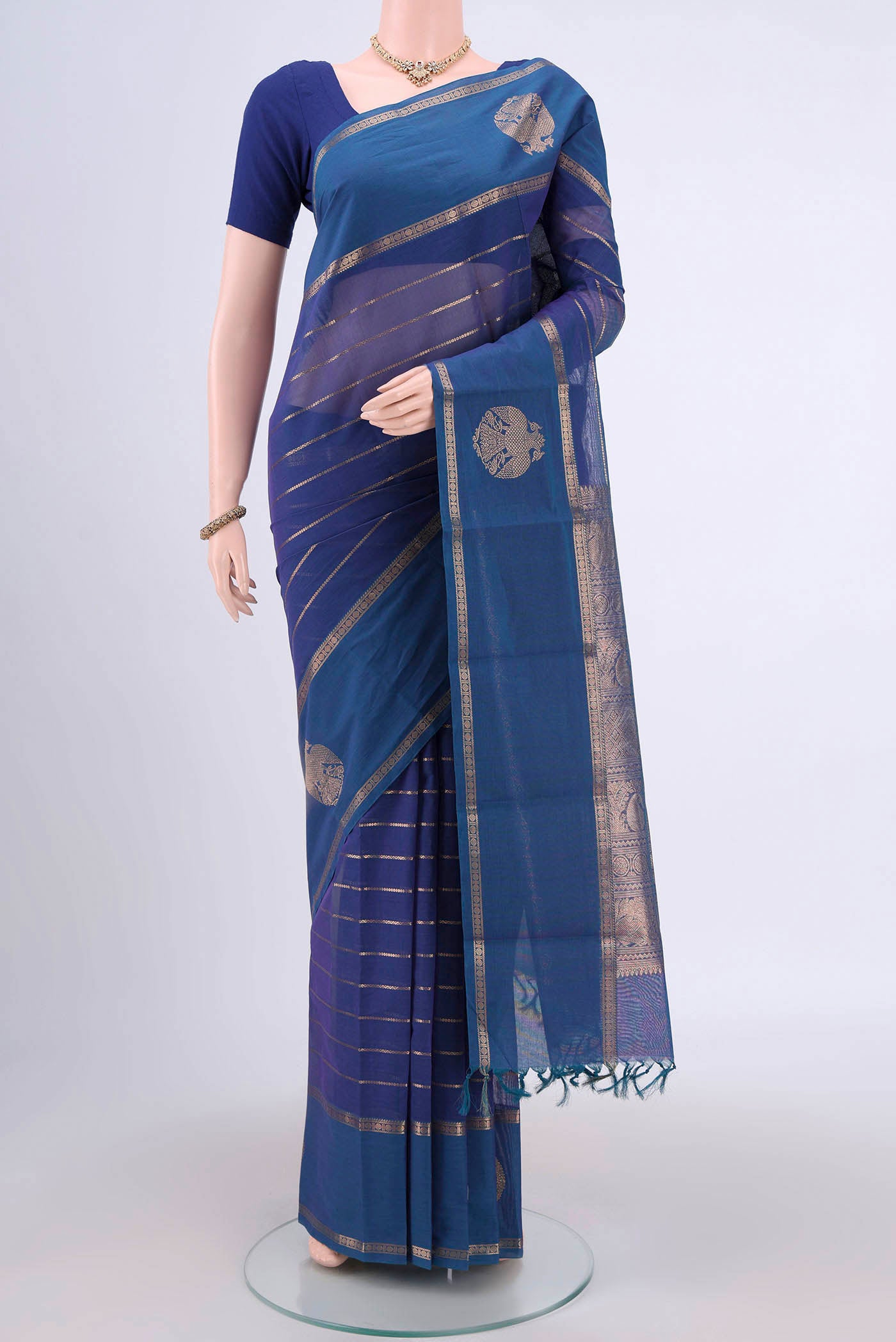Peacock Blue Kanchi Cotton Saree with Stripes on the body and Zari Border.  displayed on a mannequin