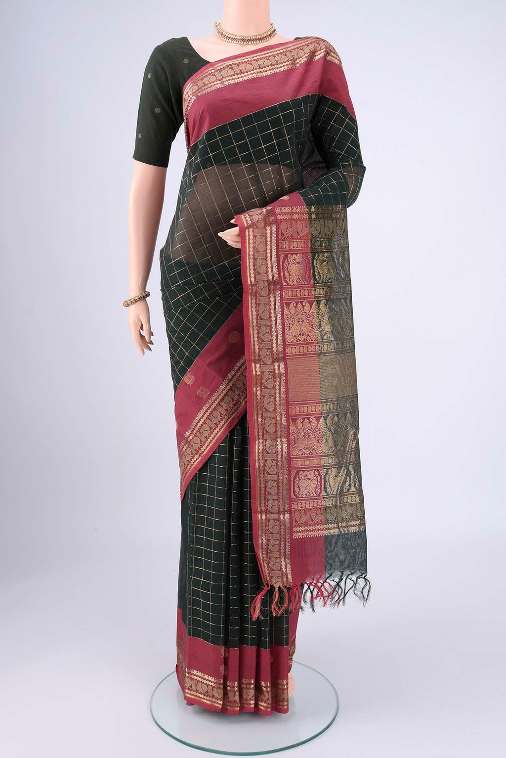 Bottle Green Kanchi Cotton Saree with Checked design on the body and Zari Border.  displayed on a mannequin