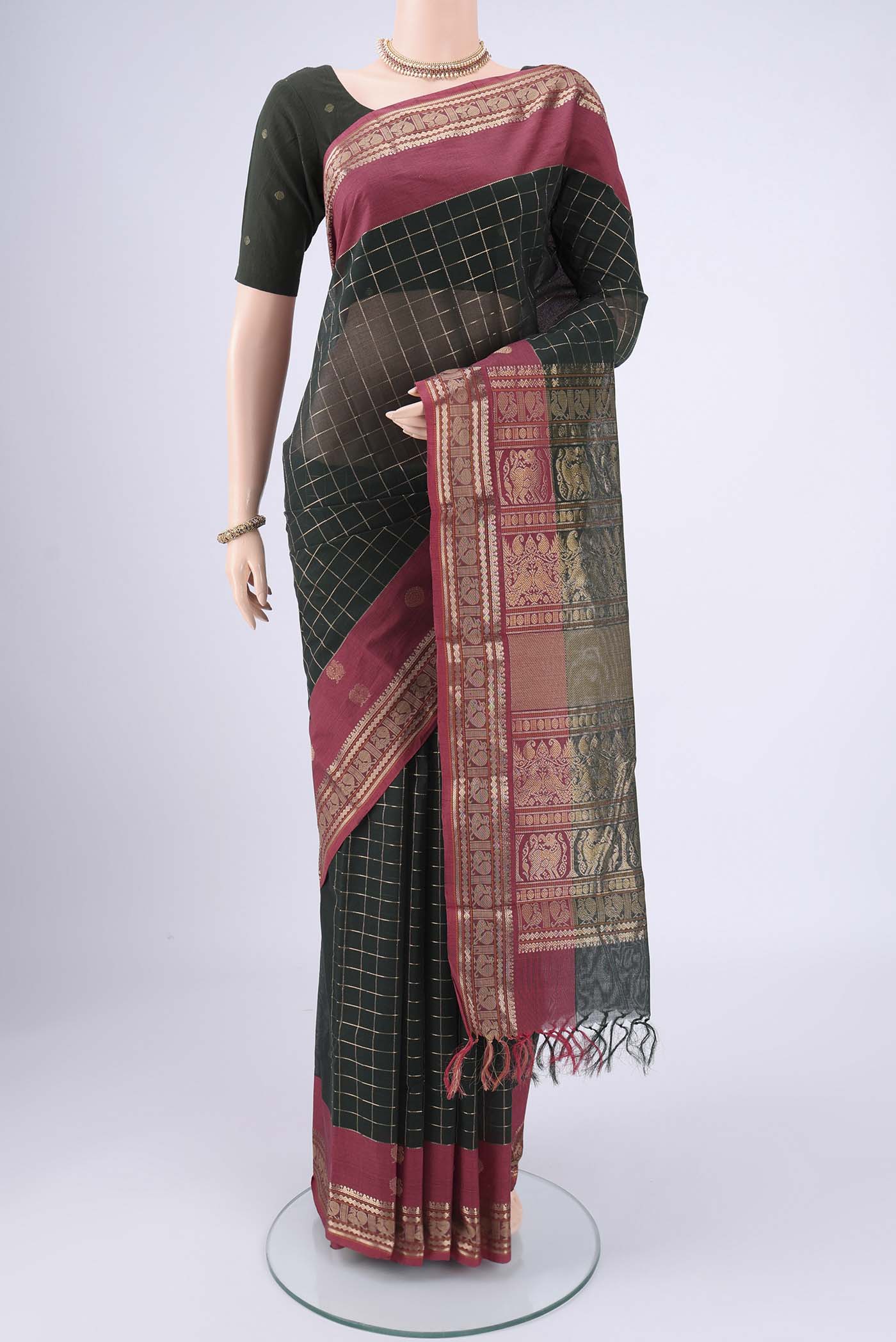 Bottle Green Kanchi Cotton Saree with Checked design on the body and Zari Border.  displayed on a mannequin