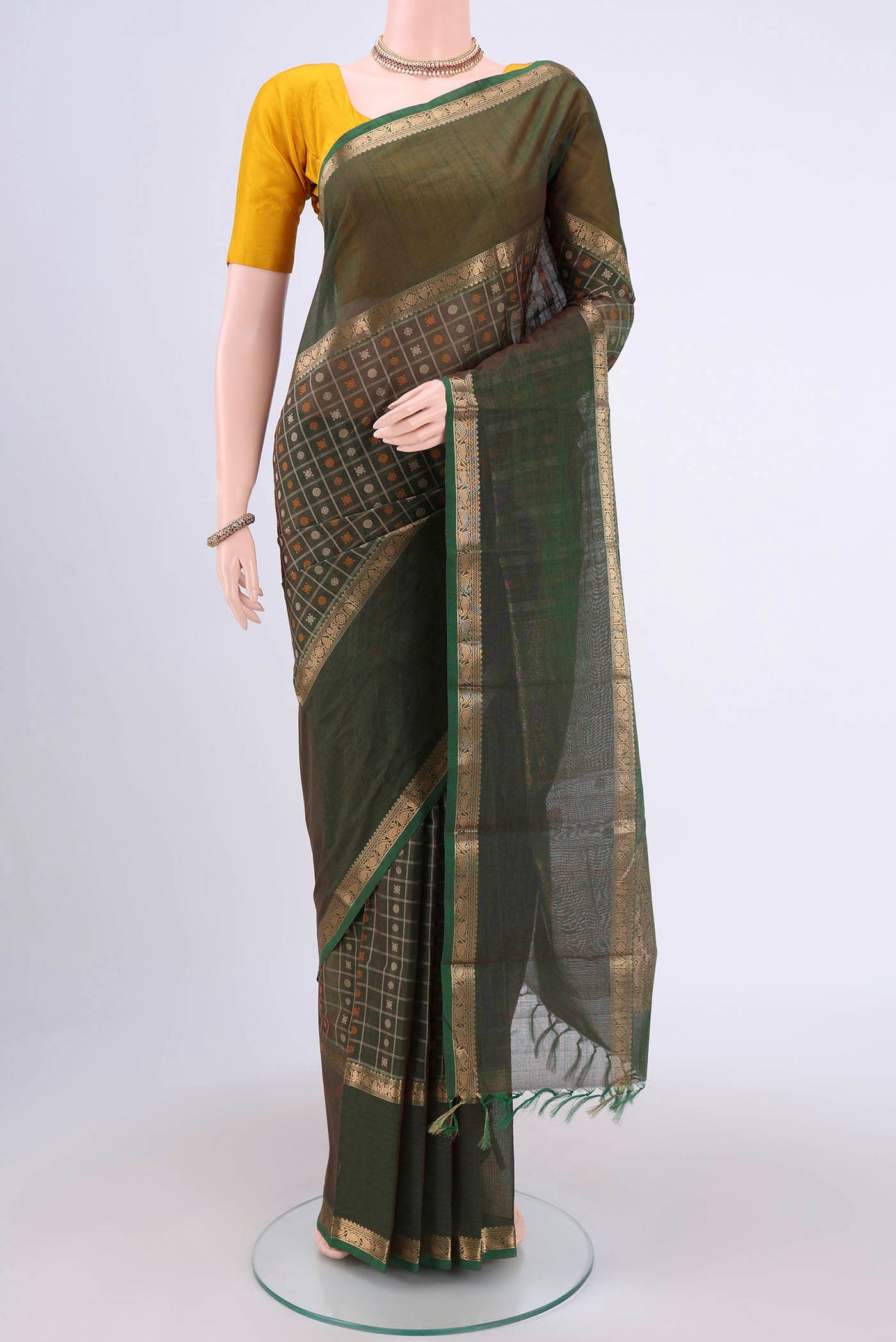 Green Kanchi Cotton Saree with Checked design on the body and Zari Border.  displayed on a mannequin