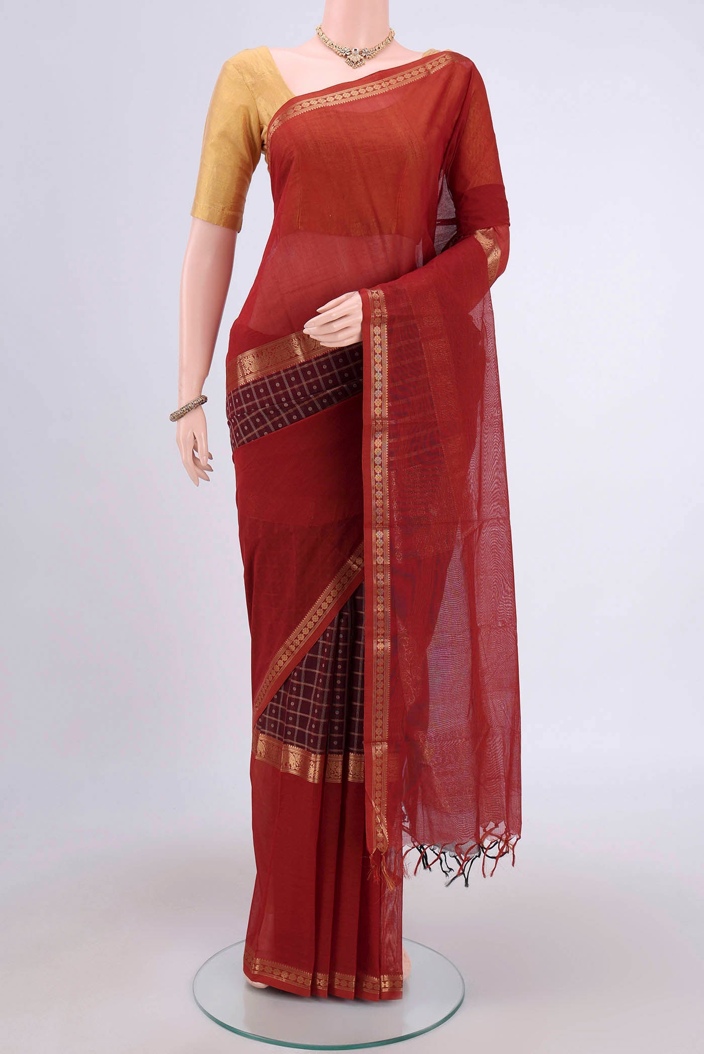 Maroon Kanchi Cotton Saree with Checked design on the body and Zari Border.  displayed on a mannequin