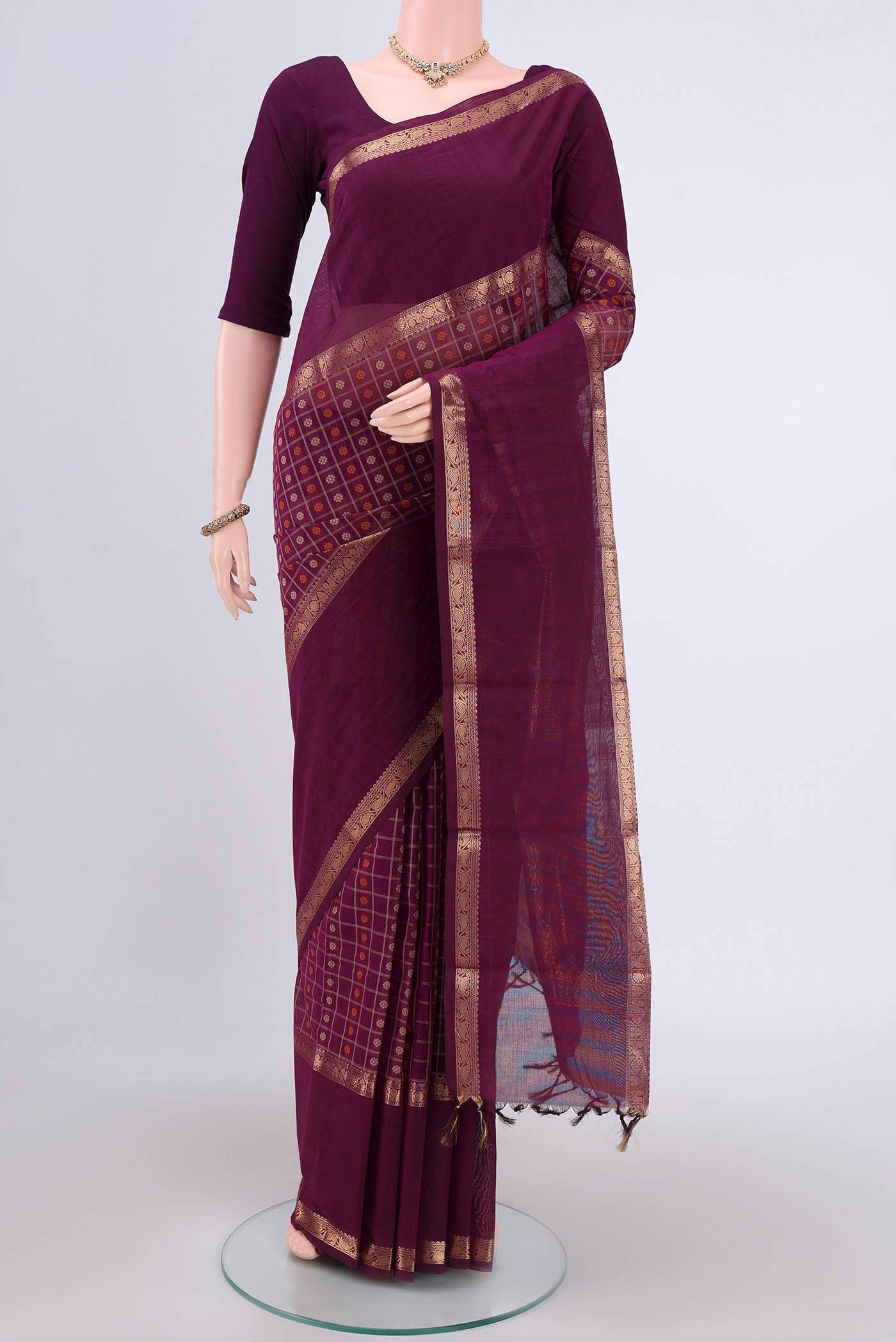 Magenta Kanchi Cotton Saree with Checked design on the body and Zari Border.  displayed on a mannequin