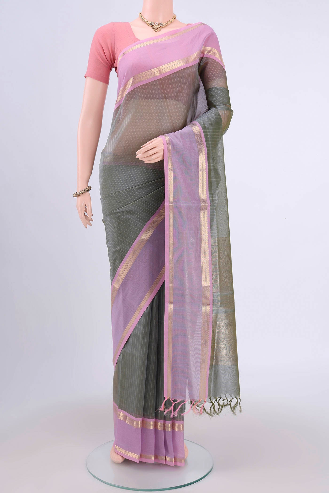 Sage Green Silk Cotton Saree with Checked design on the body and Zari Border.  displayed on a mannequin