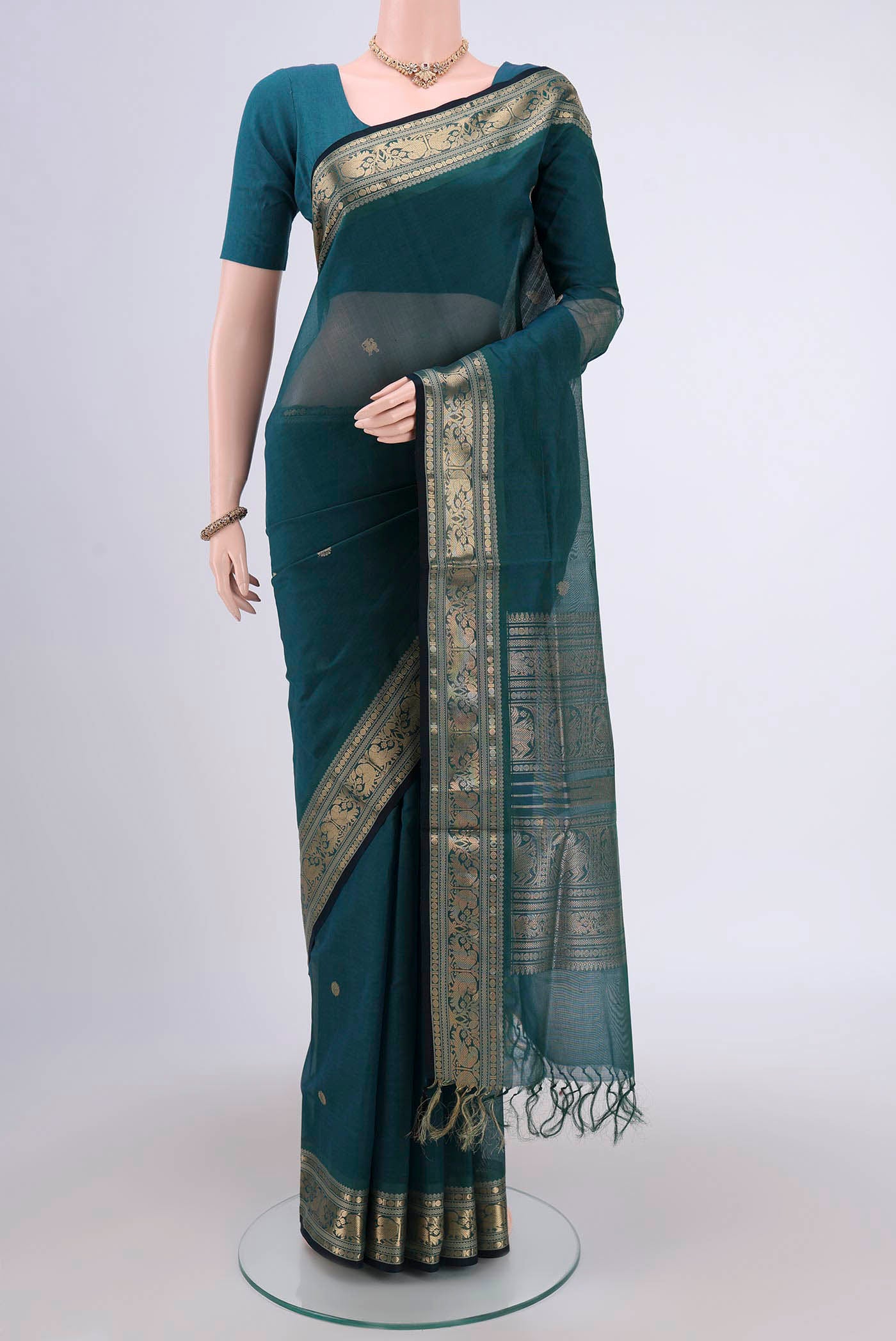 Green Silk Cotton Saree with Zari Butta on the body and Zari Border.  displayed on a mannequin