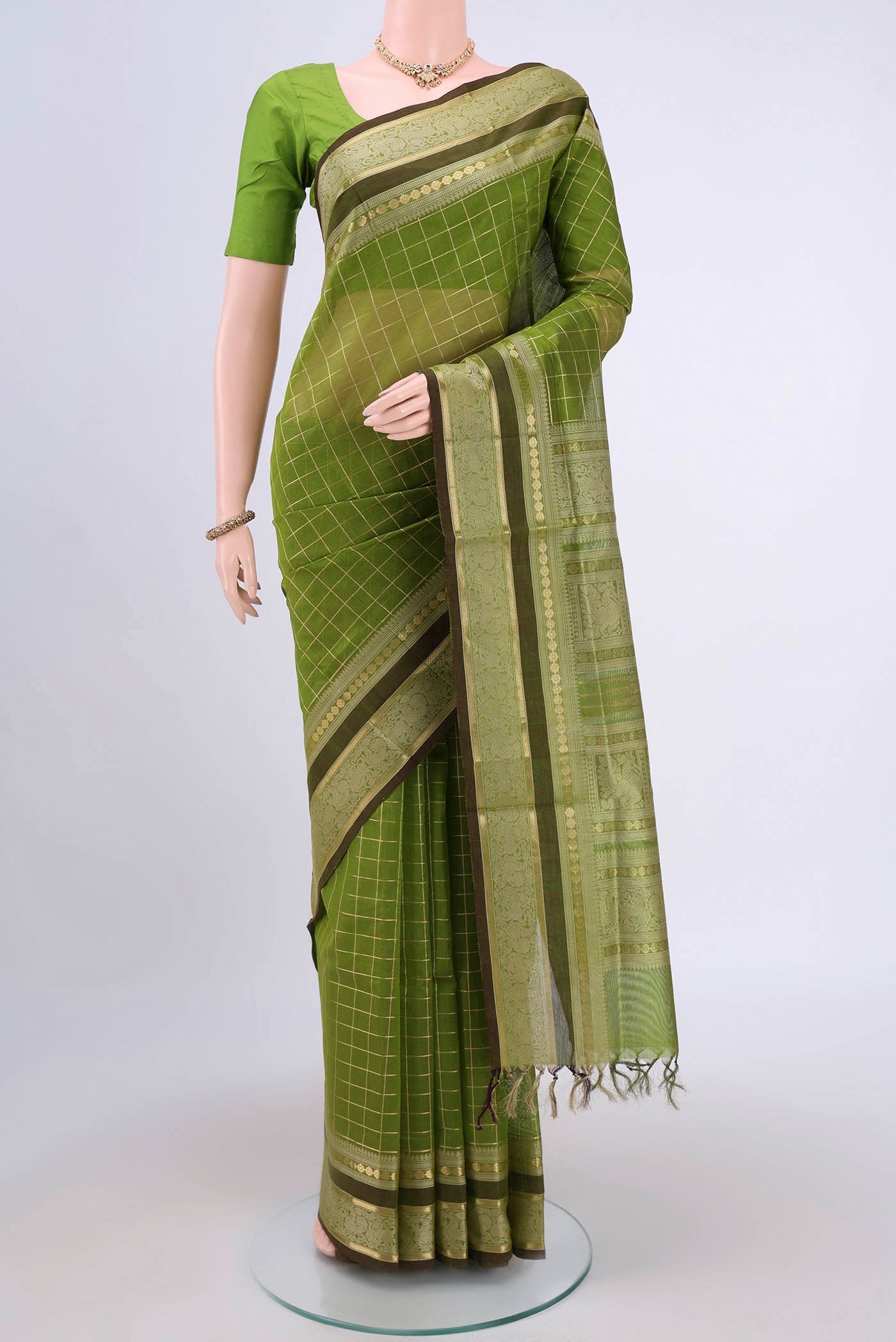 Light Green Silk Cotton Saree with Checked design on the body and Zari And Thread Border.  displayed on a mannequin