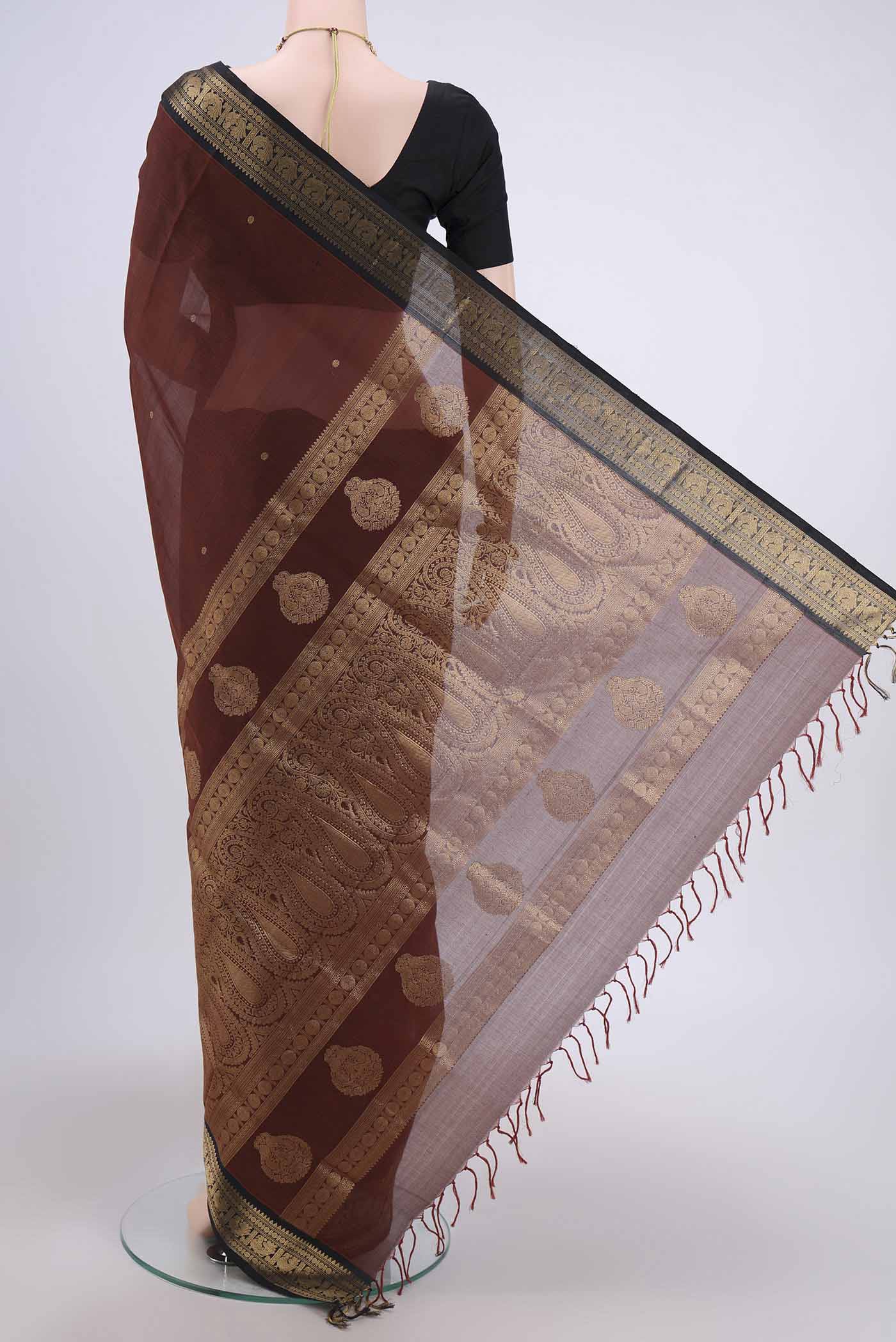 Flat view of Brown Silk Cotton Saree with Zari Butta on the body and Zari Border. 