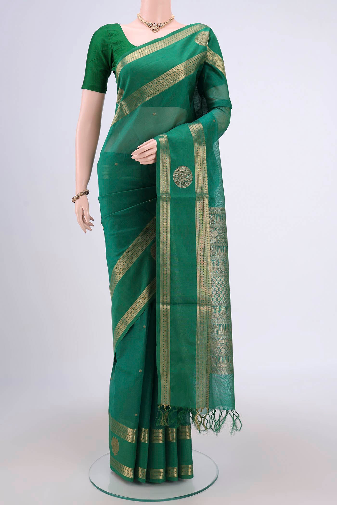 Green Silk Cotton Saree with Zari Butta on the body and Zari Border.  displayed on a mannequin