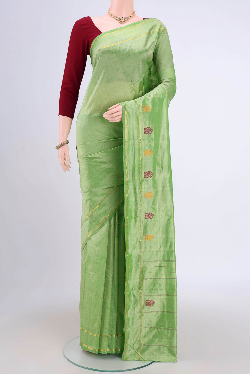 Light Green Kanchipuram Saree with Plain Body and Zari And Thread Border.  displayed on a mannequin