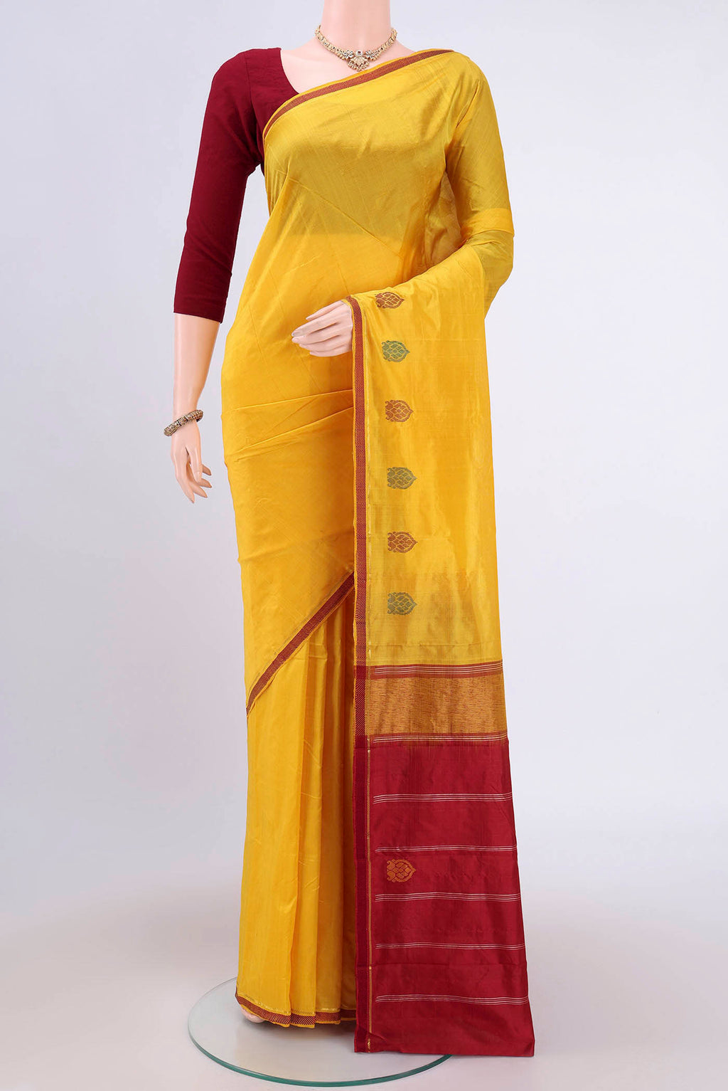 Yellow Kanchipuram Silk Saree with Plain Body and Zari And Thread Border.  displayed on a mannequin