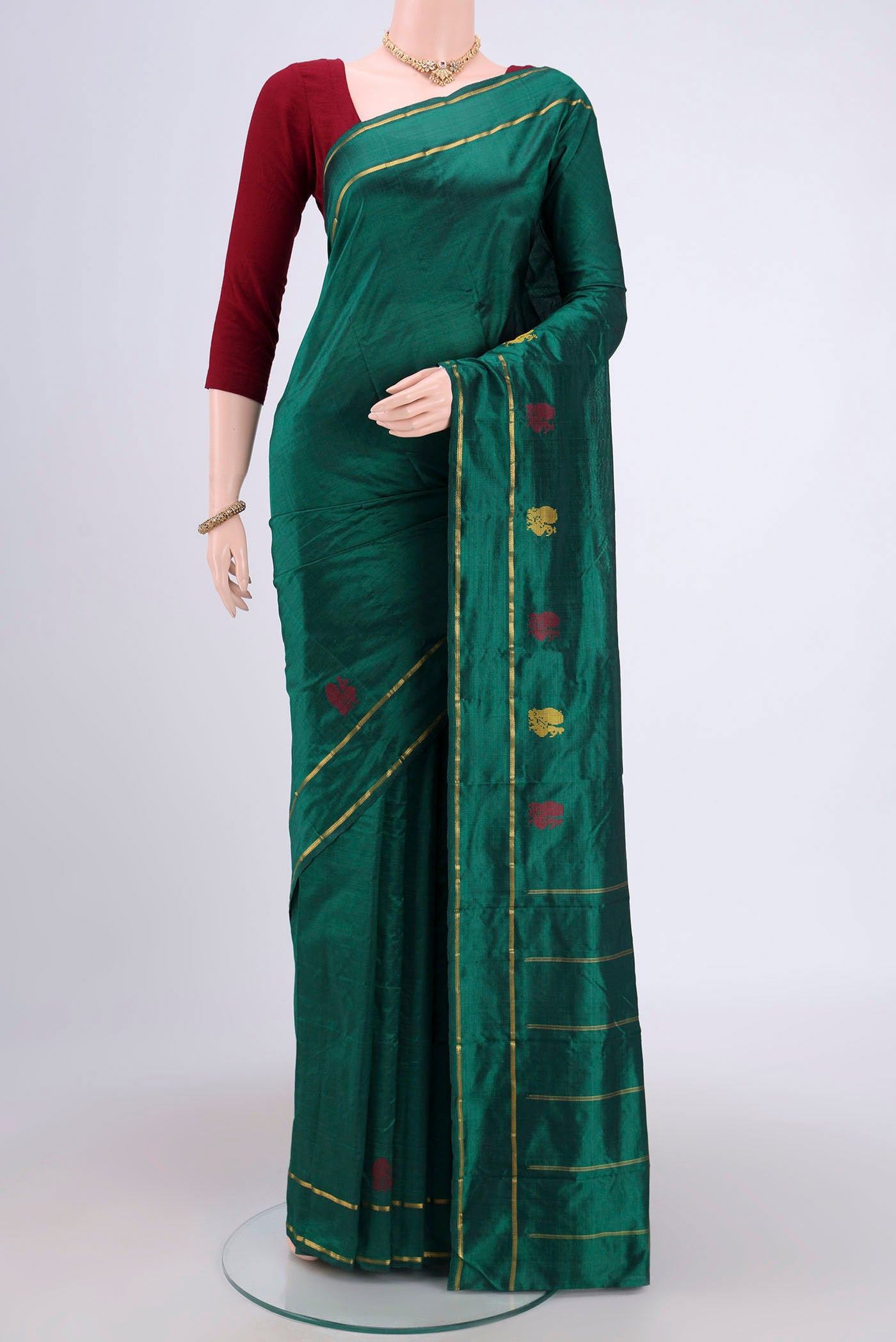 Bottle Green Kanchipuram Saree with Plain Body and Zari And Thread Border.  displayed on a mannequin