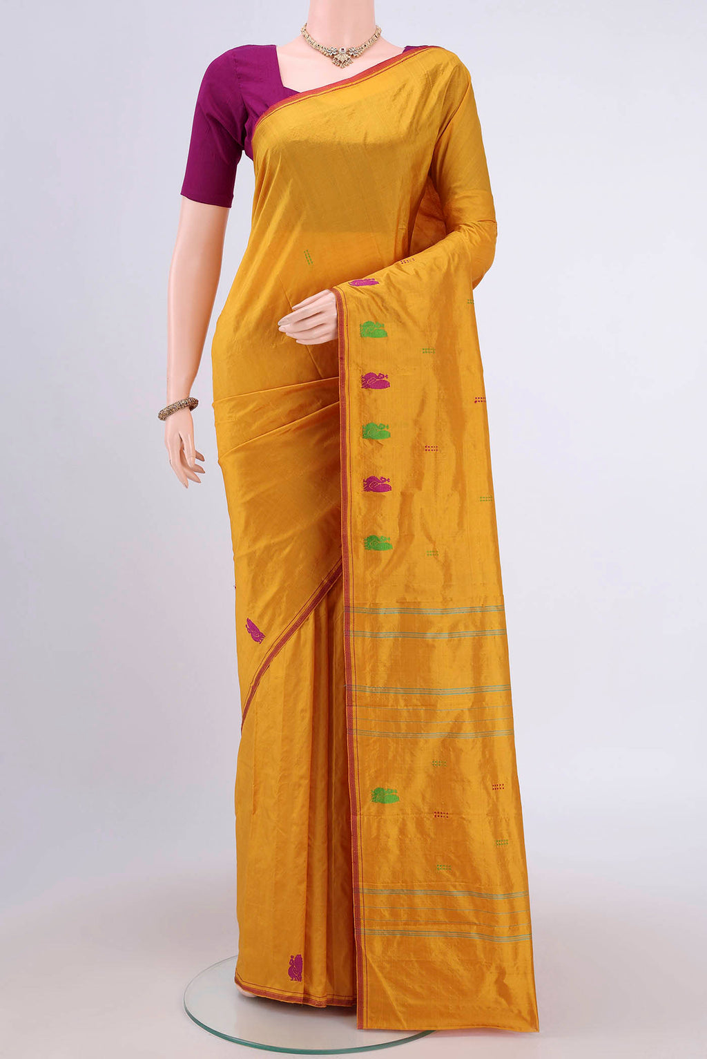 Mustard Kanchipuram Silk Saree with Thread Butta on the body and Thread Border.  displayed on a mannequin