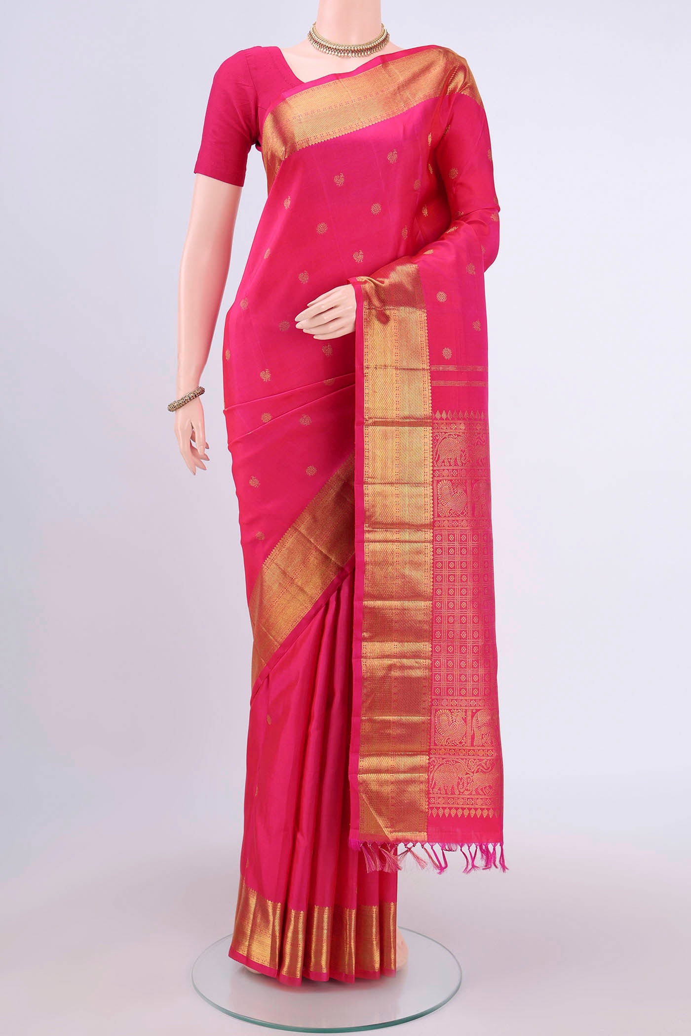 Pure Silk Pure Zari Rani Pink Dual Tone Kanjivaram Saree with Zari Butta on the body and Zari Border.  displayed on a mannequin