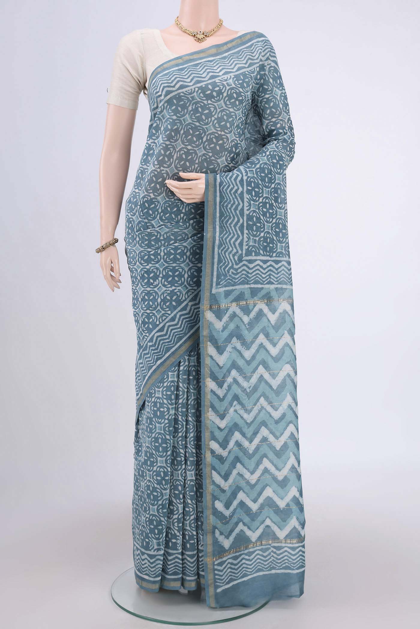 Maya Blue Maheshwari Silk Cotton Saree with Printed design on the body and Thin Zari Line.  displayed on a mannequin