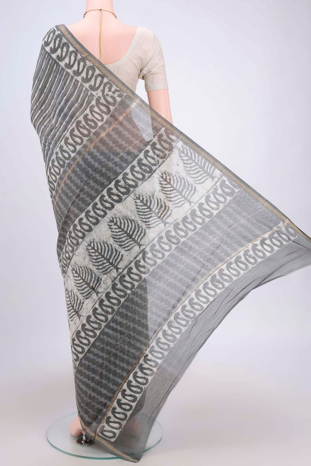 Flat view of Grey Maheshwari Silk Cotton Saree with Batik Print on the body and Zari Border. 