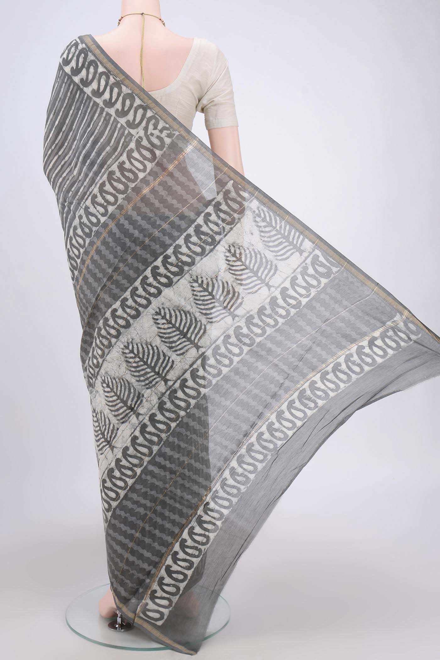 Flat view of Grey Maheshwari Silk Cotton Saree with Batik Print on the body and Zari Border. 