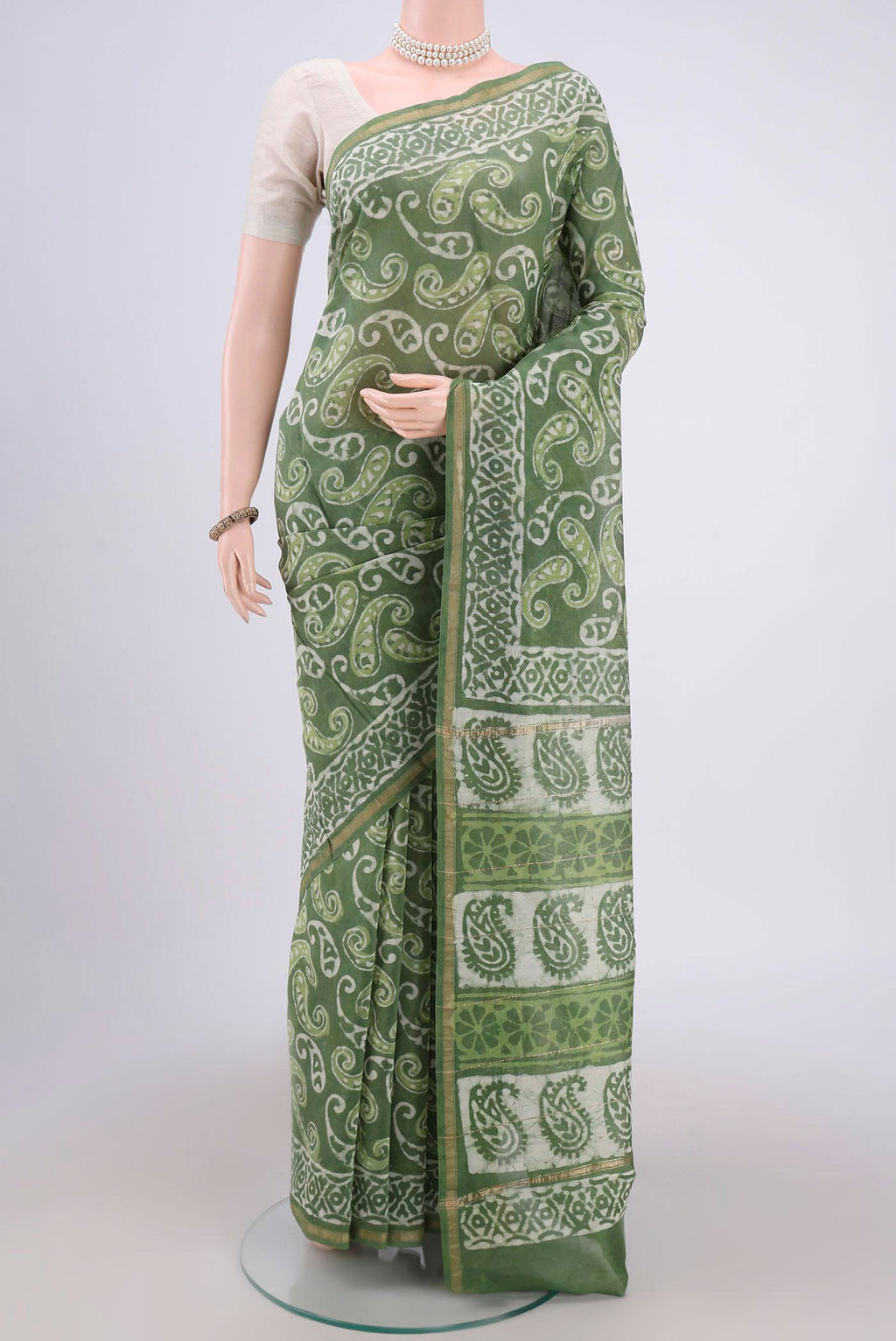 Light Green Maheshwari Silk Cotton Saree with Batik Print on the body and Zari Border.  displayed on a mannequin
