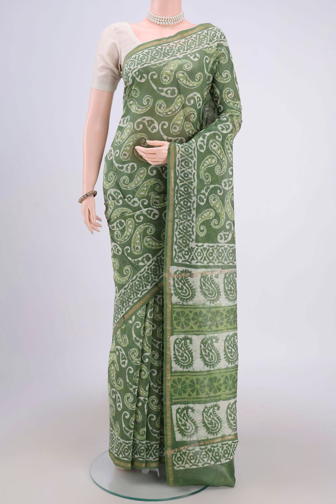 Light Green Maheshwari Silk Cotton Saree with Batik Print on the body and Zari Border.  displayed on a mannequin
