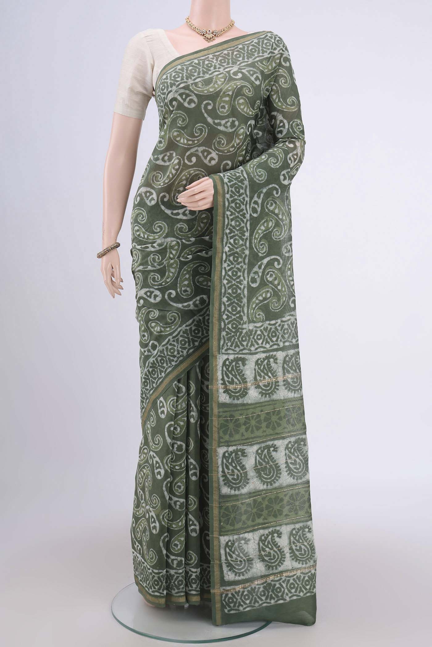 Sage Green Chanderi Silk Cotton Saree with Printed design on the body and Zari Border.  displayed on a mannequin