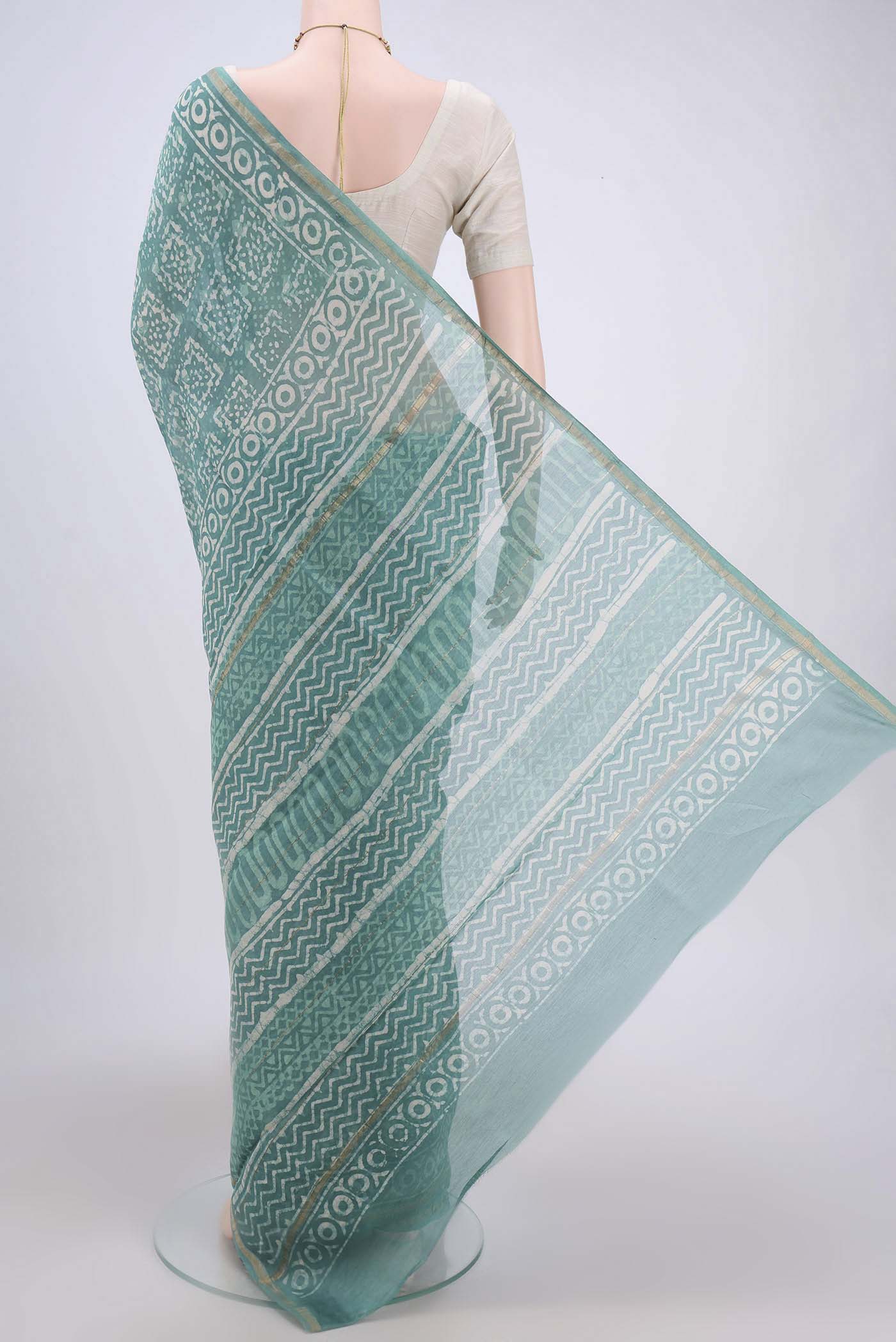 Flat view of Turquoise Maheshwari Silk Cotton Saree with Batik Print on the body and Zari Border. 