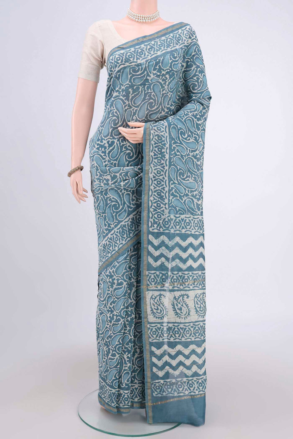 Blue Maheshwari Silk Cotton Saree with Batik Print on the body and Zari Border.  displayed on a mannequin