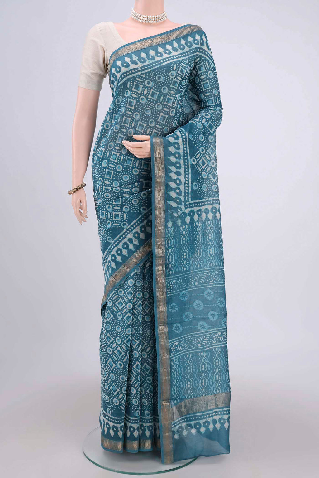 Blue Maheshwari Silk Cotton Saree with Batik Print on the body and Zari Border.  displayed on a mannequin