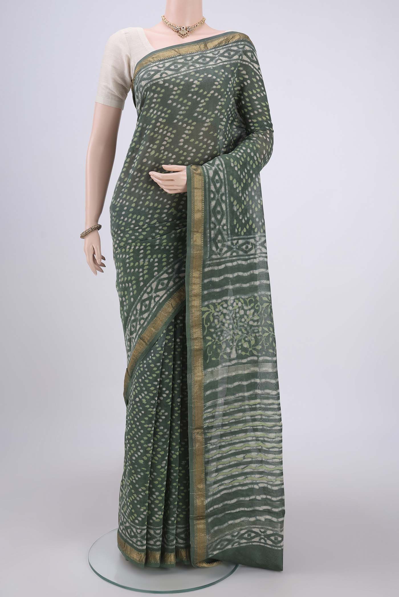 Olive Green Maheshwari Silk Cotton Saree with Batik Print on the body and Zari Border.  displayed on a mannequin