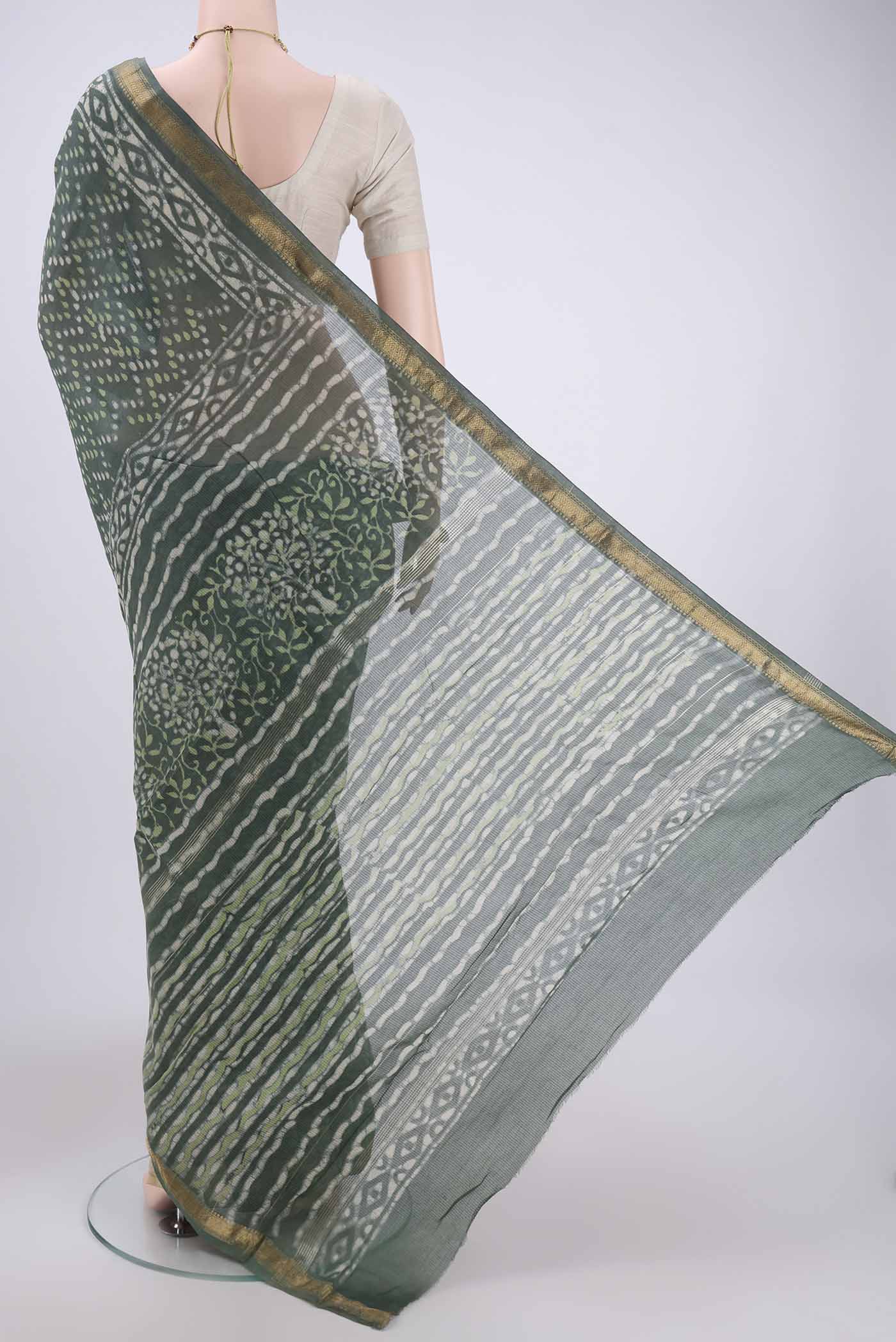 Flat view of Olive Green Maheshwari Silk Cotton Saree with Batik Print on the body and Zari Border. 