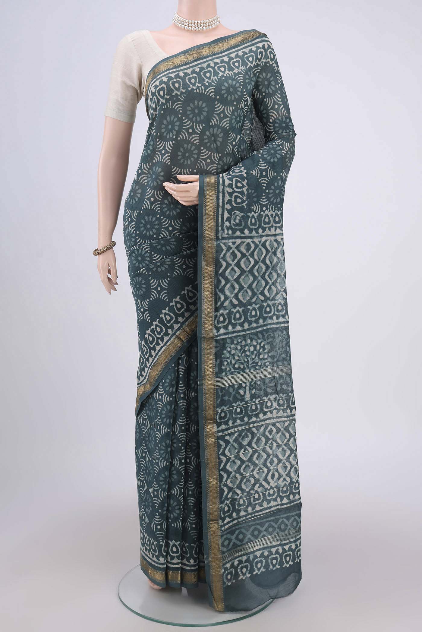 Blue Grey Maheshwari Silk Cotton Saree with Batik Print on the body and Zari Border.  displayed on a mannequin