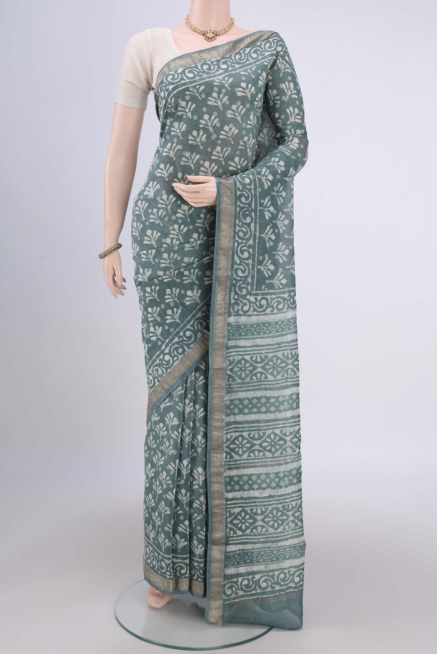 Blue Grey Maheshwari Silk Cotton Saree with Batik Print on the body and Zari Border.  displayed on a mannequin