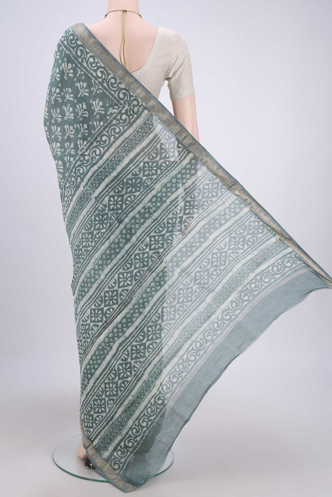 Flat view of Blue Grey Maheshwari Silk Cotton Saree with Batik Print on the body and Zari Border. 