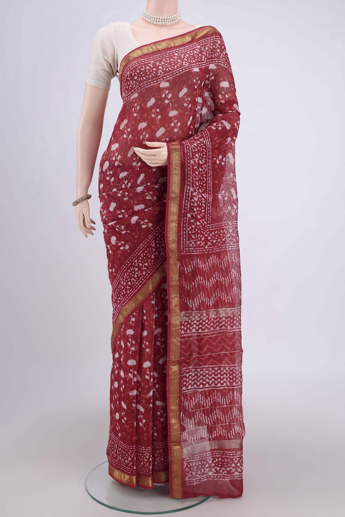 Coral Maheshwari Silk Cotton Saree with Batik Print on the body and Zari Border.  displayed on a mannequin