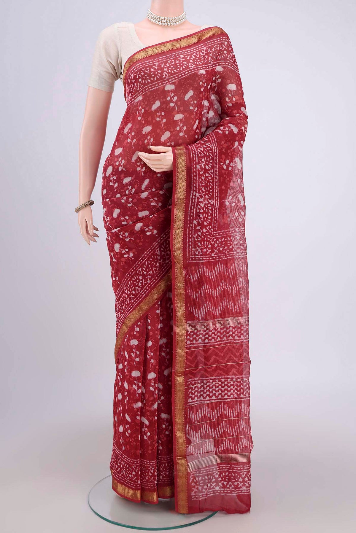 Coral Maheshwari Silk Cotton Saree with Batik Print on the body and Zari Border.  displayed on a mannequin
