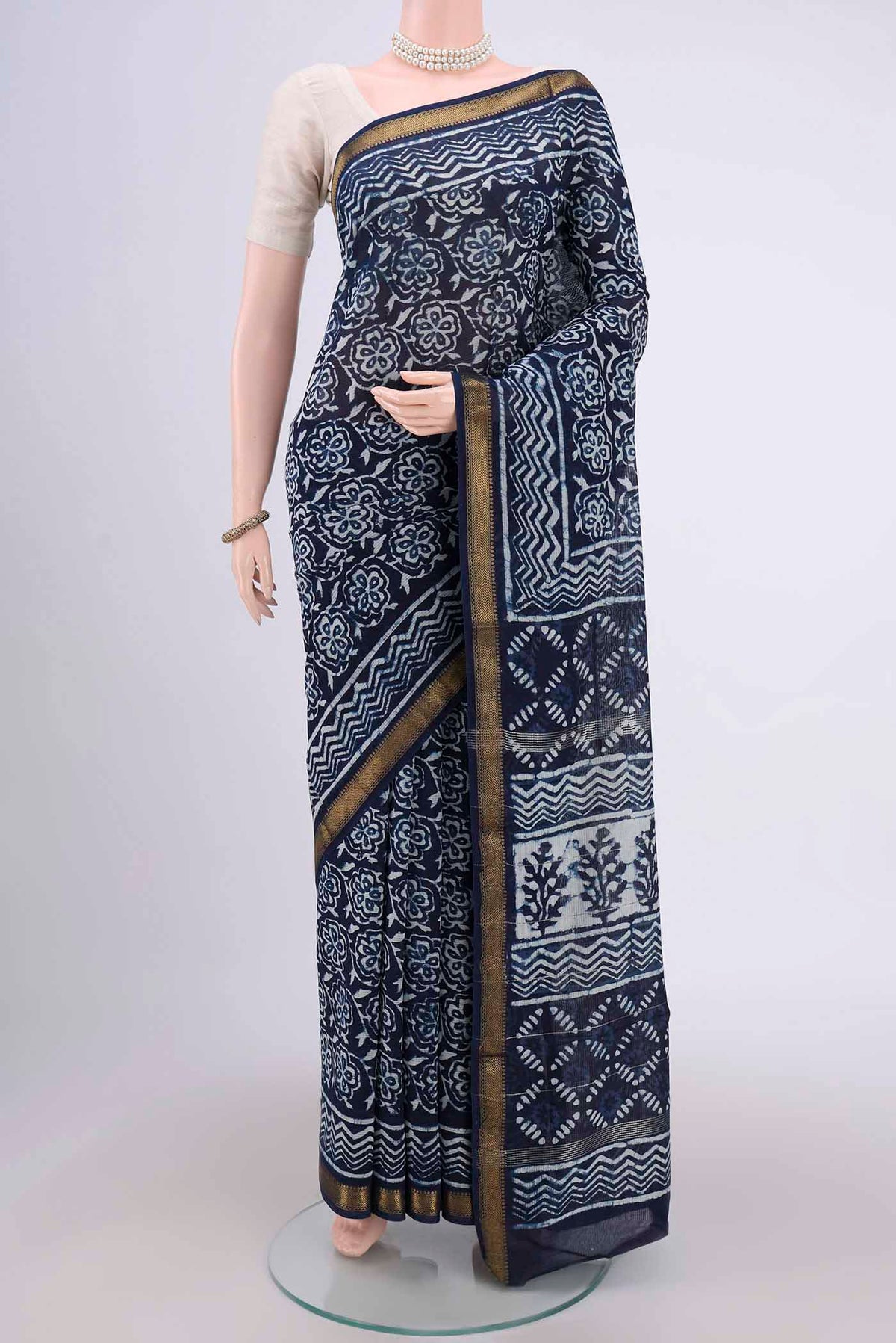 Indigo Maheshwari Silk Cotton Saree with Batik Print on the body and Zari Border.  displayed on a mannequin