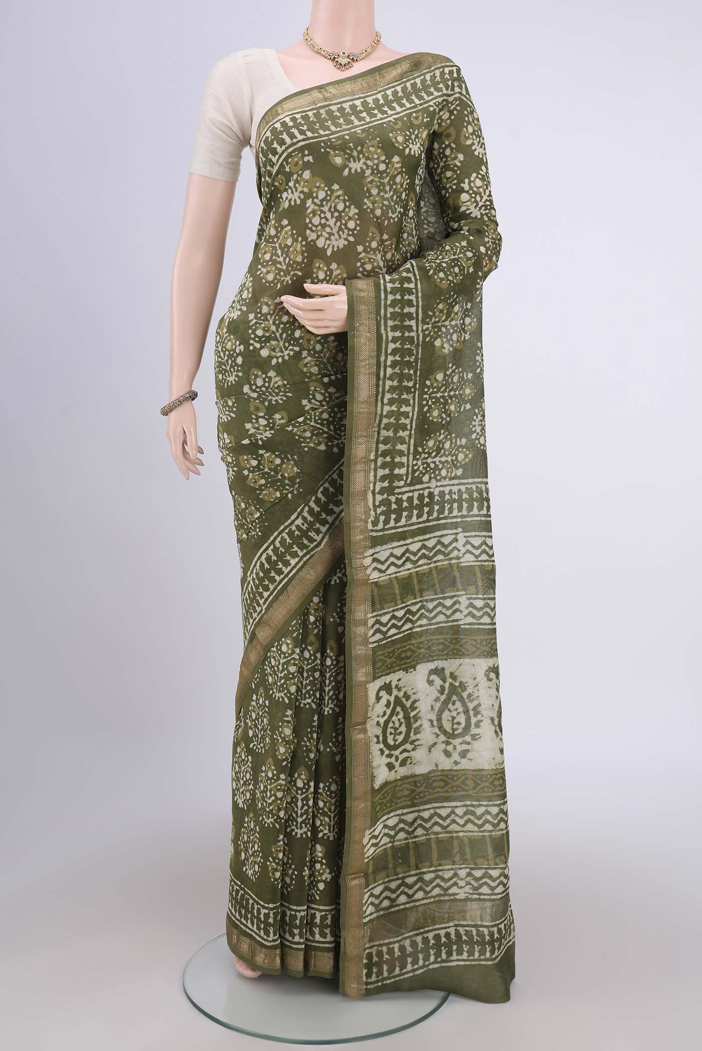 Mehandi Green Maheshwari Silk Cotton Saree with Batik Print on the body and Zari Border.  displayed on a mannequin