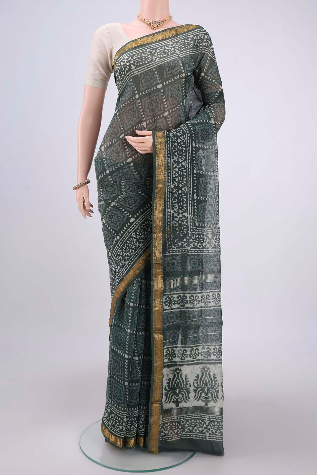 Olive Green Maheshwari Silk Cotton Saree with Batik Print on the body and Zari Border.  displayed on a mannequin