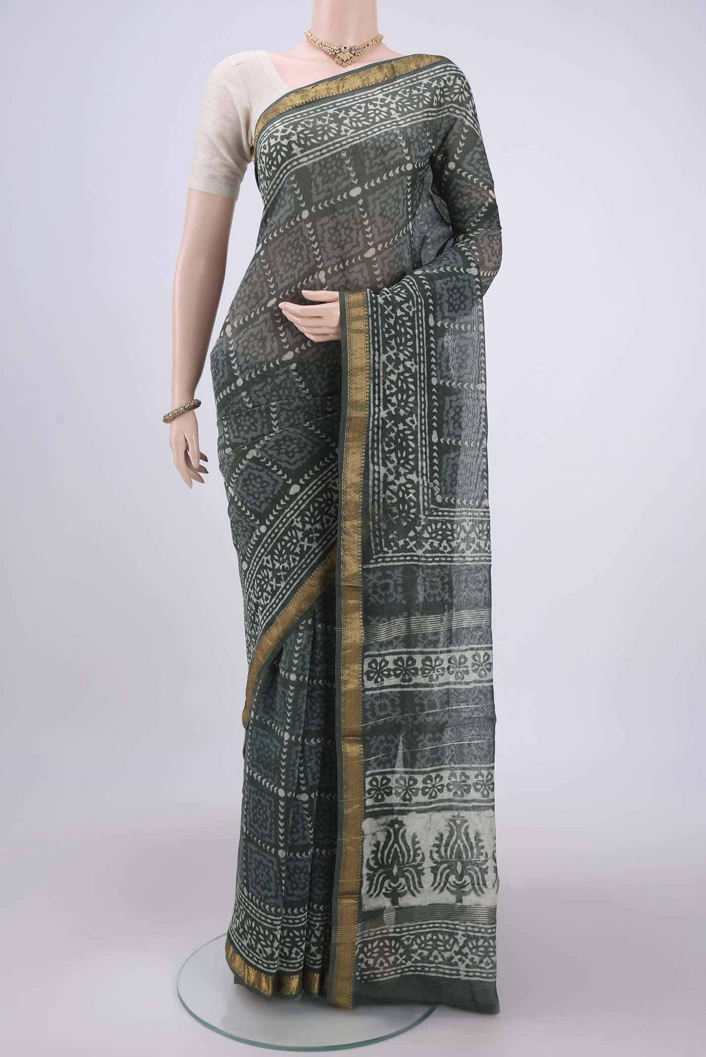 Olive Green Maheshwari Silk Cotton Saree with Batik Print on the body and Zari Border.  displayed on a mannequin