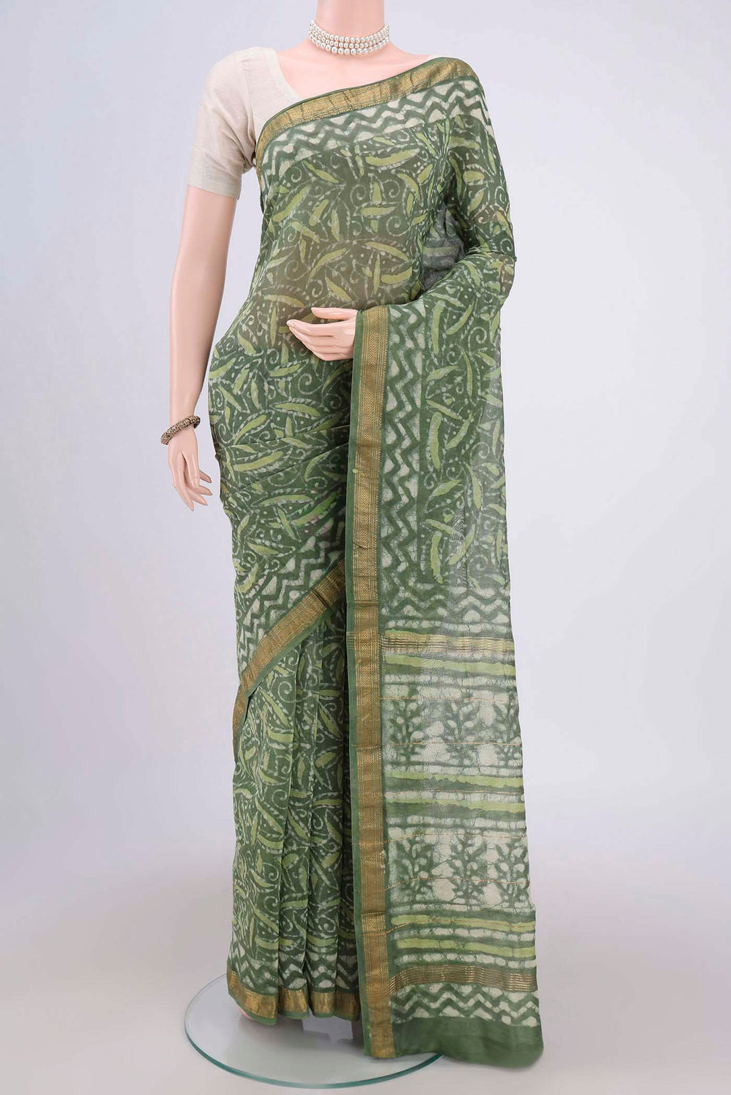 Olive Green Maheshwari Silk Cotton Saree with Batik Print on the body and Zari Border.  displayed on a mannequin