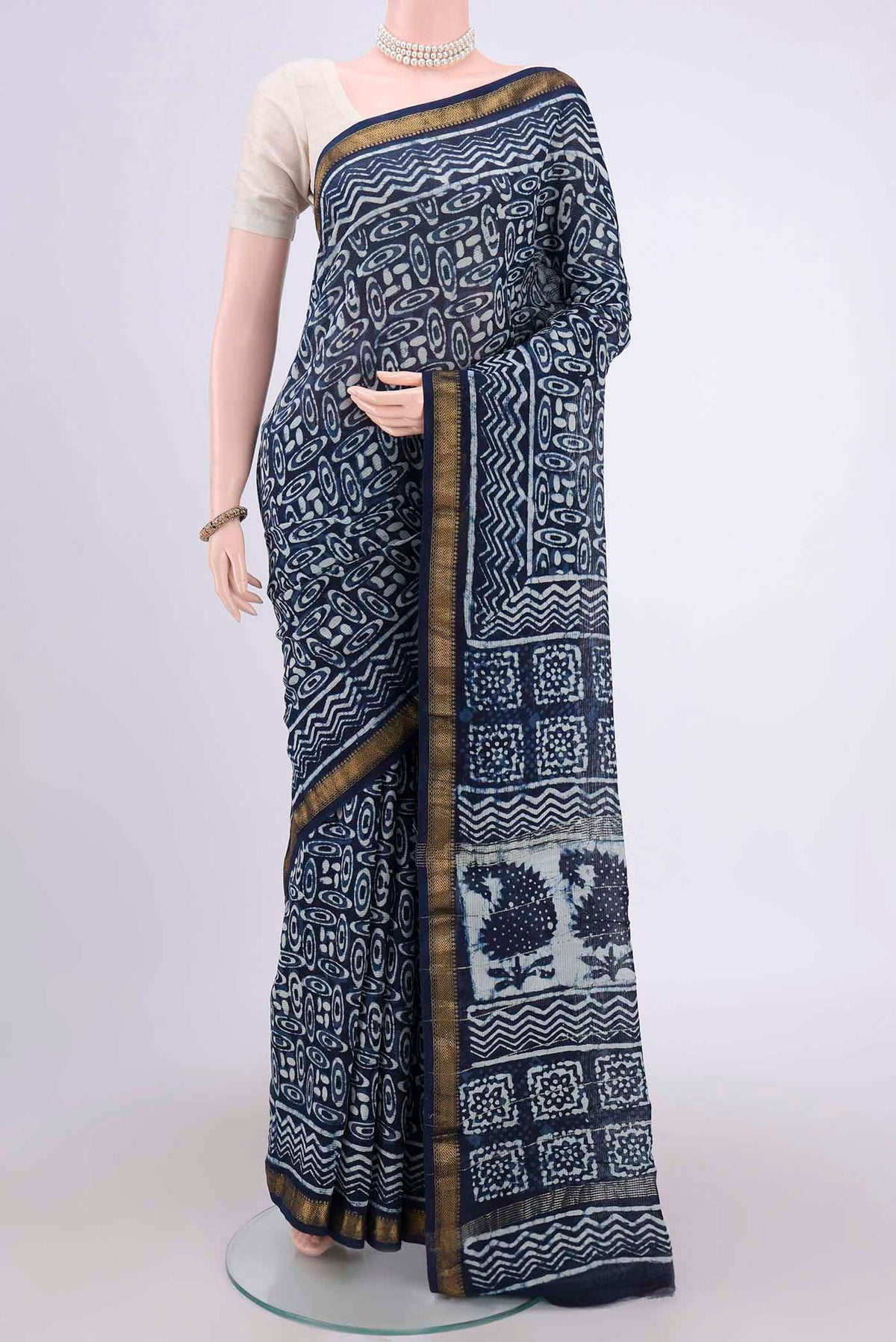 Indigo Maheshwari Silk Cotton Saree with Batik Print on the body and Zari Border.  displayed on a mannequin