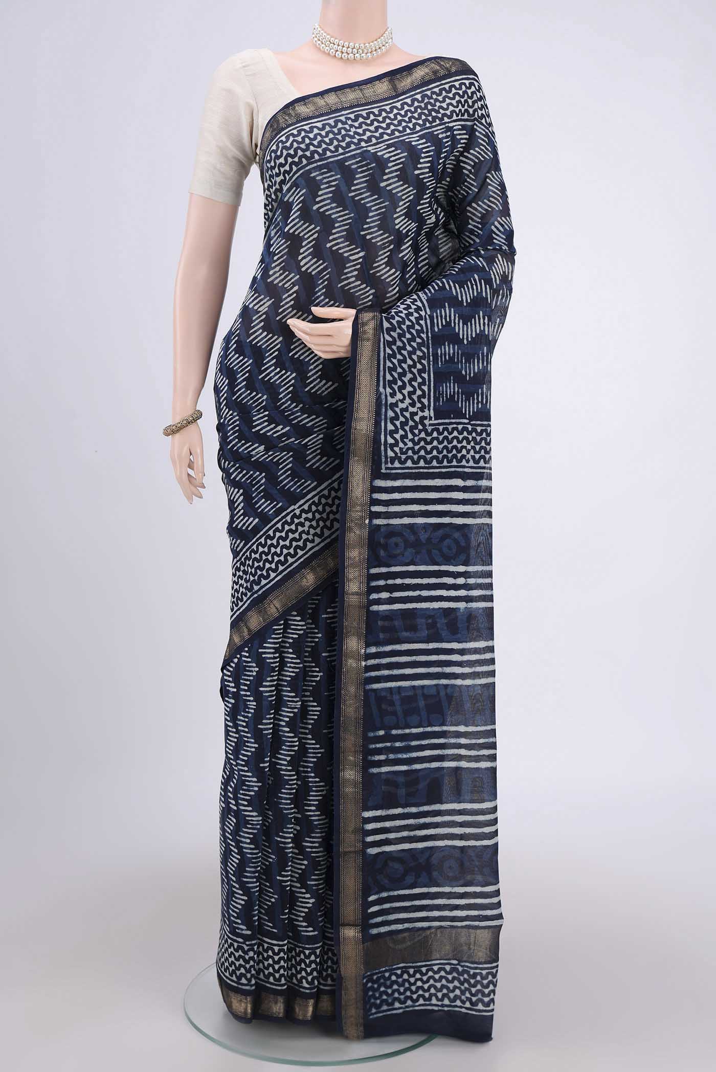Indigo Maheshwari Silk Cotton Saree with Batik Print on the body and Zari Border.  displayed on a mannequin