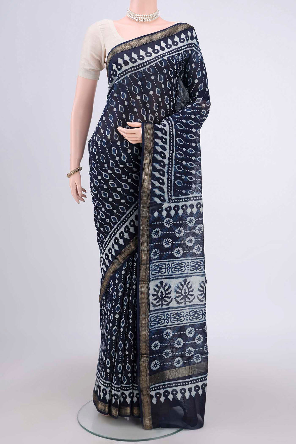 Indigo Maheshwari Silk Cotton Saree with Batik Print on the body and Zari Border.  displayed on a mannequin
