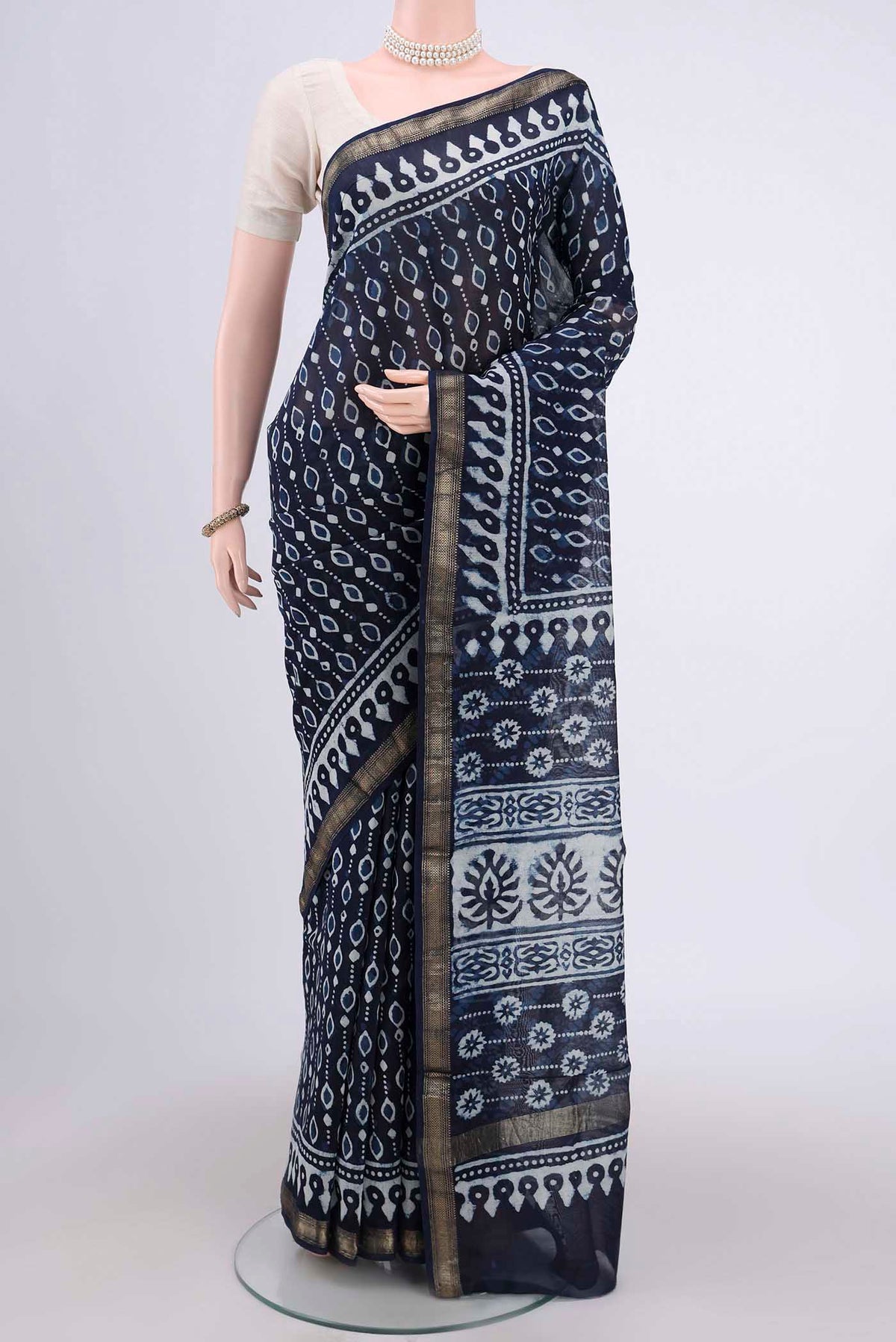 Indigo Maheshwari Silk Cotton Saree with Batik Print on the body and Zari Border.  displayed on a mannequin