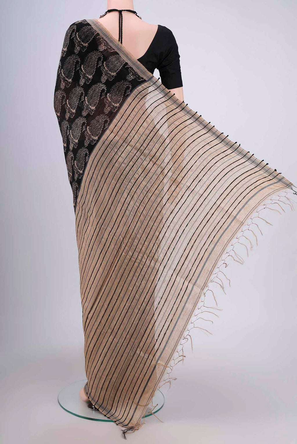 Flat view of Black Tussar Silk Saree with Printed design on the body and Plain Border. 