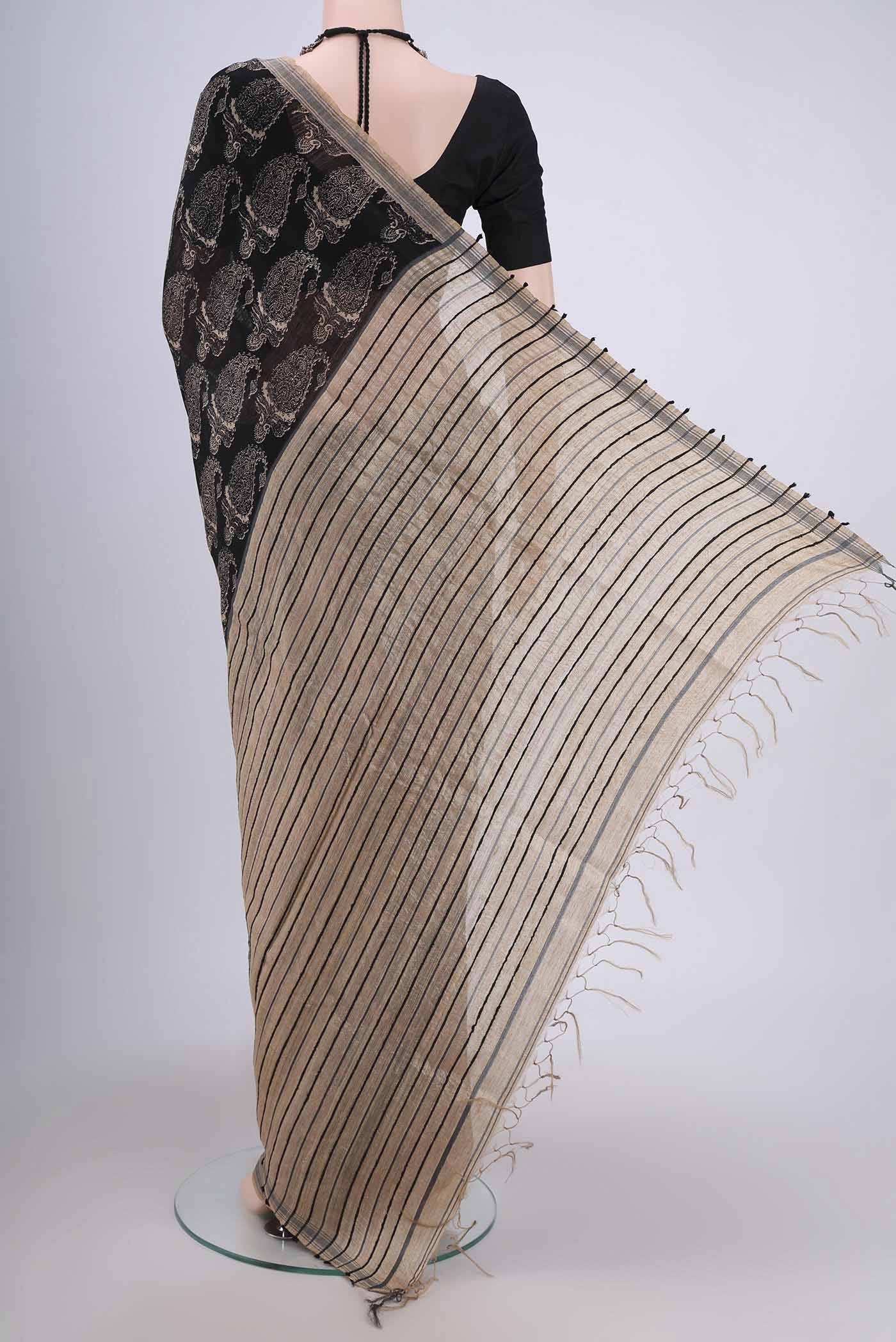 Flat view of Black Tussar Silk Saree with Printed design on the body and Plain Border. 