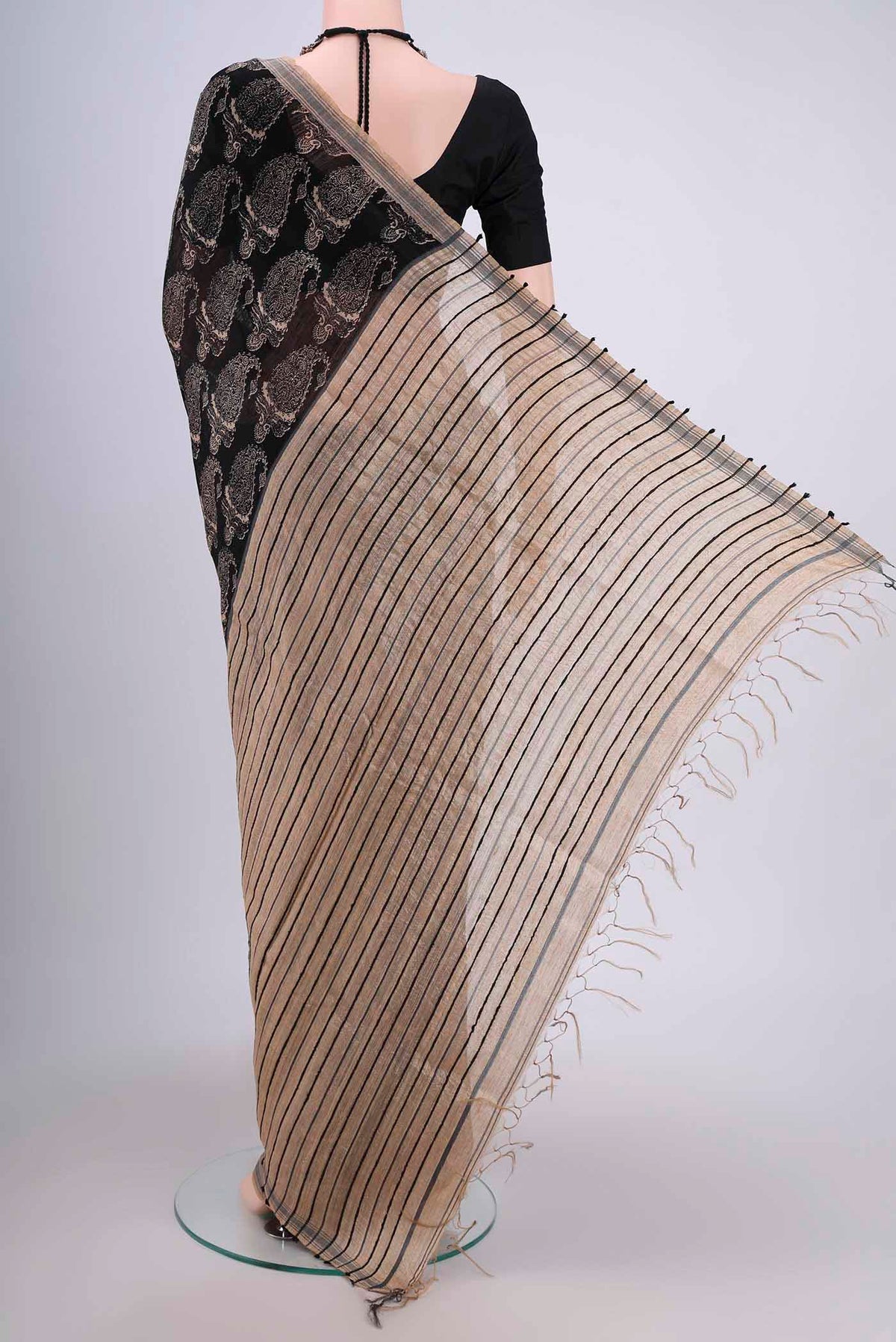 Flat view of Black Tussar Silk Saree with Printed design on the body and Plain Border. 