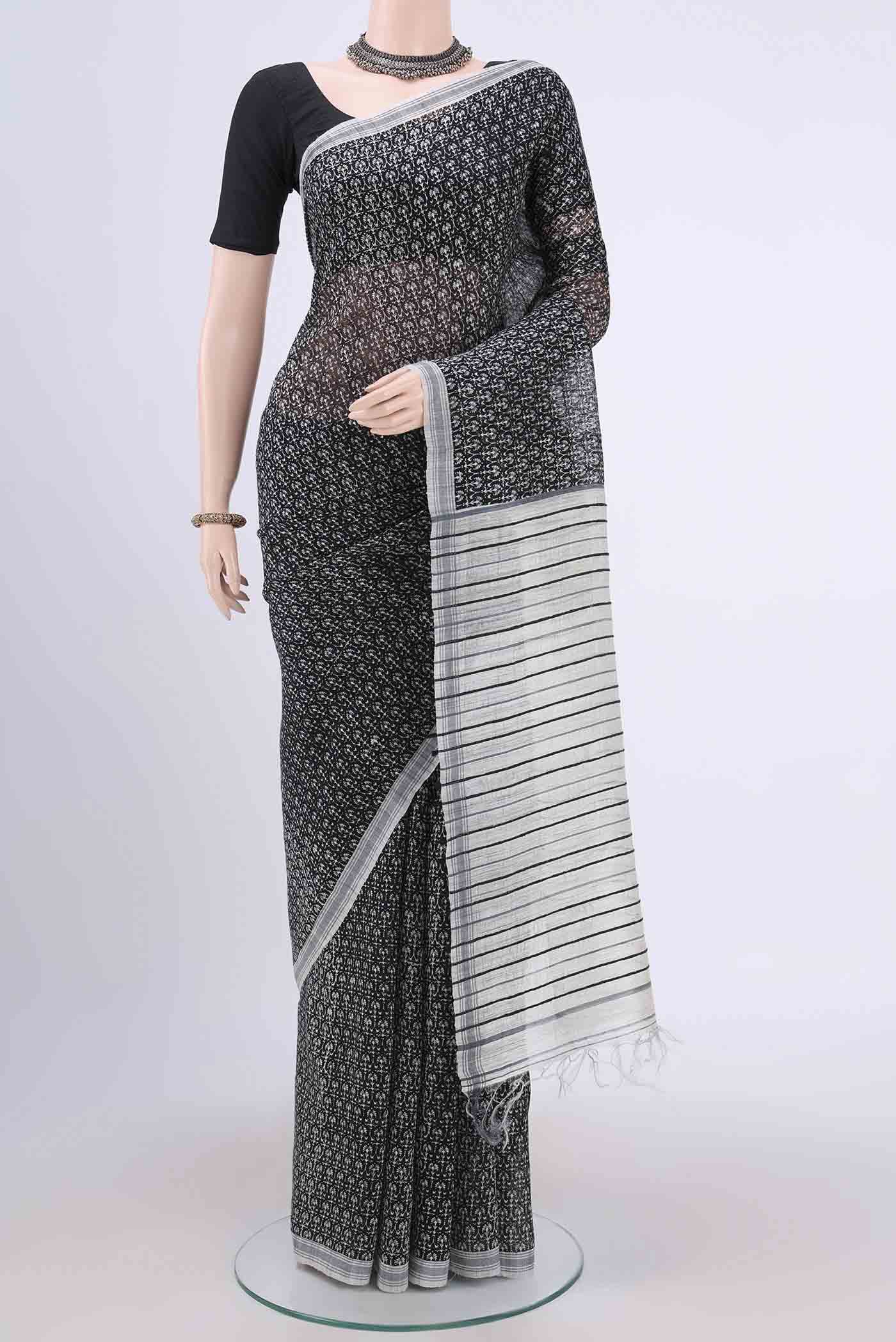 Black Tussar Silk Saree with Printed design on the body and Plain Border.  displayed on a mannequin