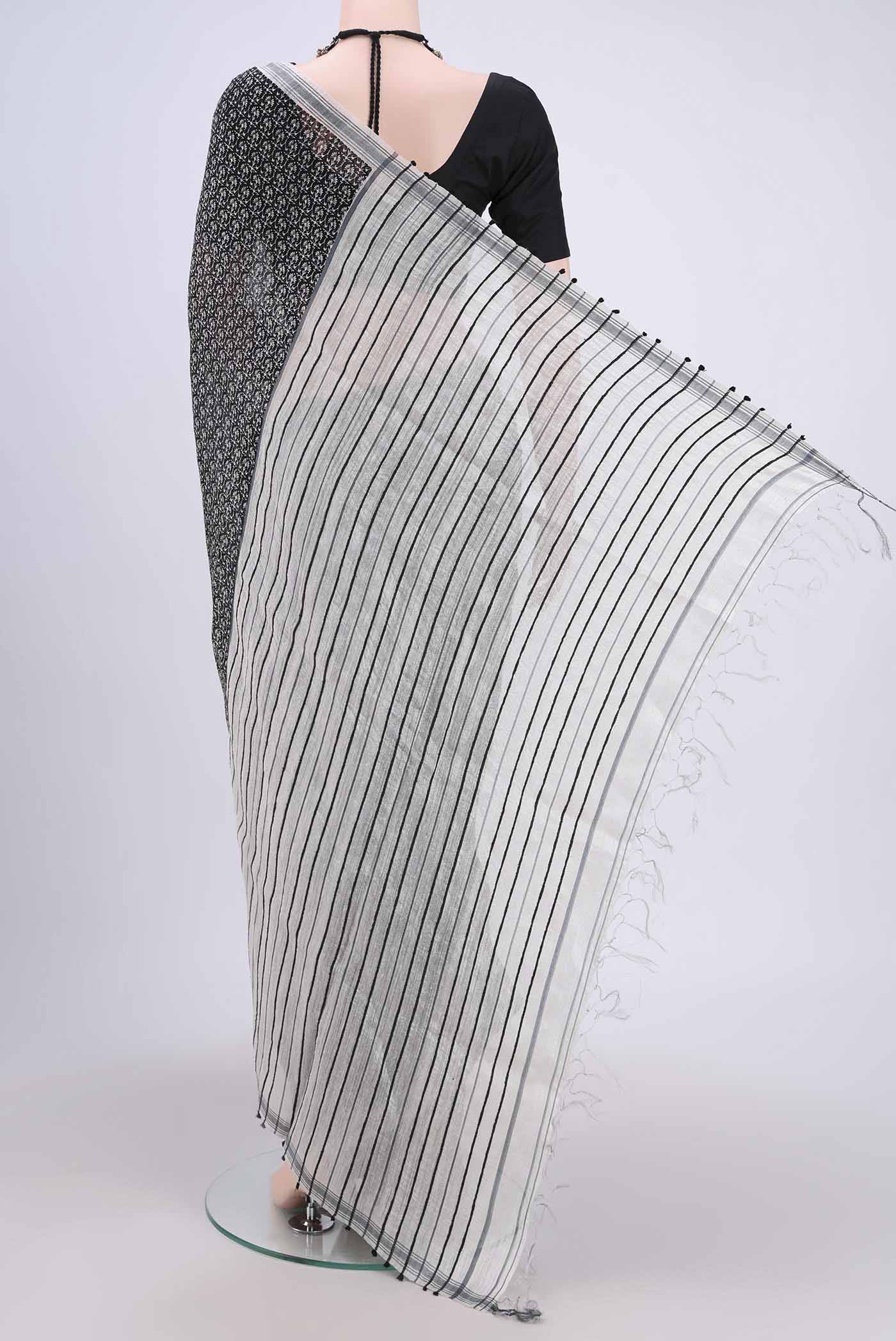 Flat view of Black Tussar Silk Saree with Printed design on the body and Plain Border. 