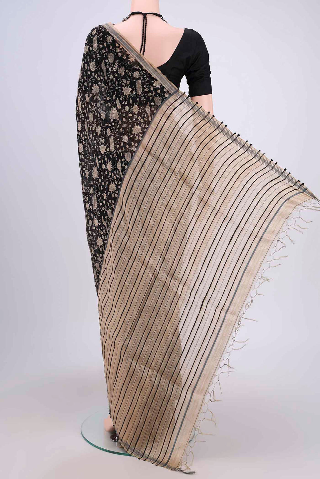 Flat view of Black Tussar Silk Saree with Printed design on the body and Plain Border. 